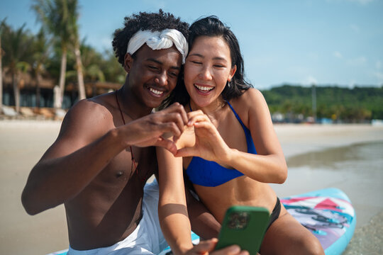 Carefree couple enjoying a tropical beach vacation, laughing making unforgettable memories together