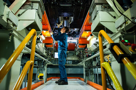 Auto Worker Inspecting Car Chassis