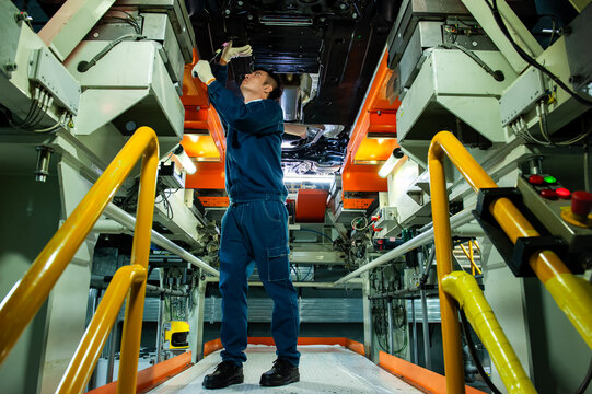 Auto Worker Inspecting Car Chassis
