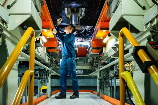Auto Worker Inspecting Car Chassis