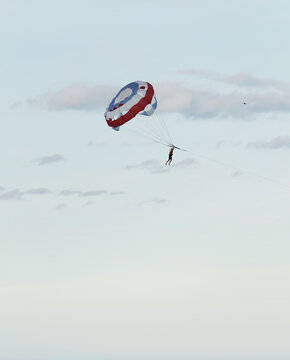 Parasailing over the sea. Da Nang coast. Active leisure. Parachute against a blue sky.