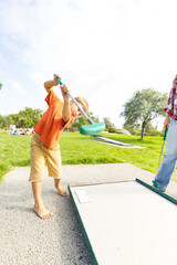 Obraz premium Child enjoying mini golf in park learning game