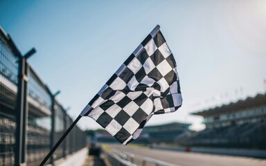 Fototapeta premium Black and white checkered racing flag waving at a racetrack