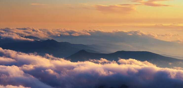 Golden sunrise lighting up mountain peaks above a thick cloud inversion layer with mountain landscape inversion atmosphere altitude wilderness outdoors mountainous background