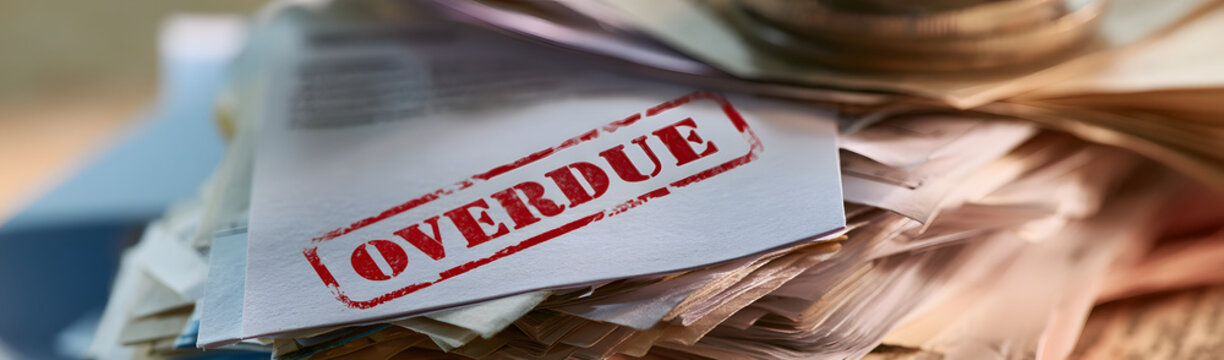A stack of overdue bills: A close-up showing a disorganized collection of notes and documents, with the OVERDUE label clearly visible, symbolizing financial difficulties. A sense of stress and urgency
