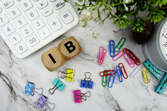 IC (Information Coefficient) alphabet letters with calculator and alarm clock on marble background