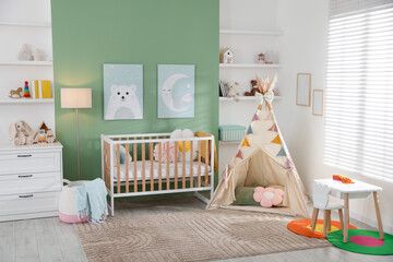 Cute baby room interior with comfortable crib, wigwam and other toys © New Africa