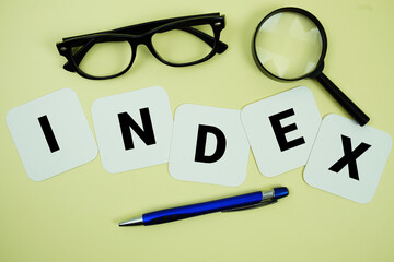 Fototapeta premium INDEX alphabet letters with magnifying glass, eye glasses and pen on yellow background