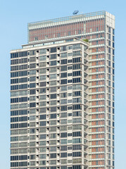 Fototapeta premium Bottom up view green condominium building with blue sky background