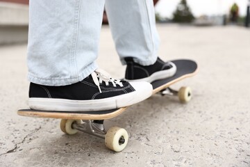 Man riding skateboard on city street, closeup © New Africa
