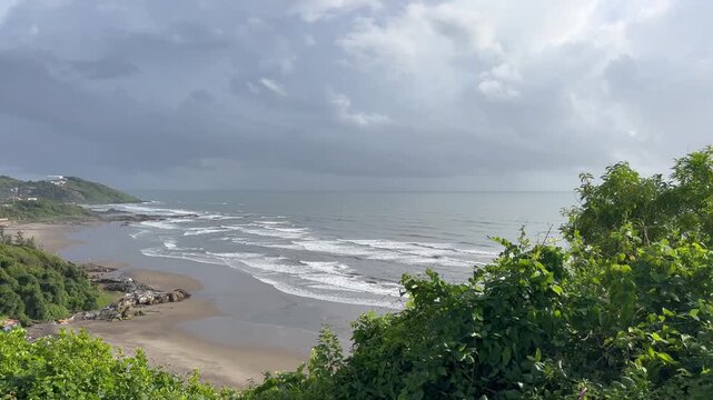 Panoramic panning view of Vagator beach coastline and green hills from Chapora Fort hill in North Goa India