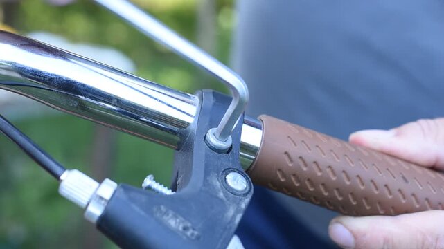 Men's hands tighten a bolt with an Allen key.