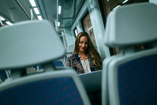 Businesswoman working on laptop while riding train