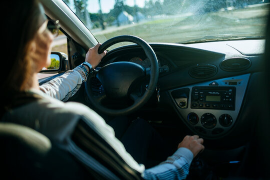 Businesswoman driving car on sunny day