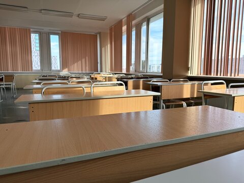 Empty school classroom with wooden desks and chairs, bright study room interior.	