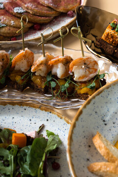 Close up shrimp and mango chutney canapes in glass plate. Mini sandwiches and other dishes