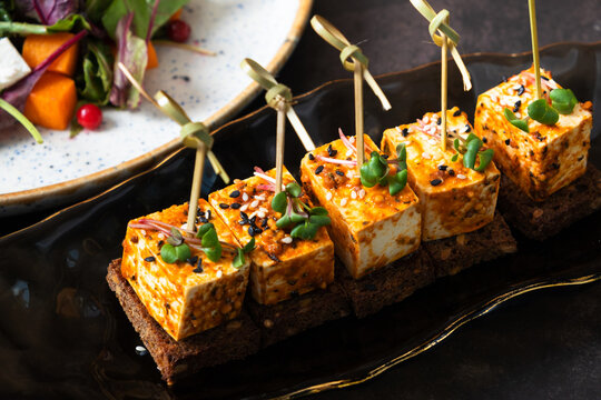 Close up sandwiches with pickled soft cheese on dark background