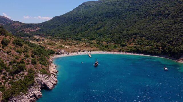 Kakome bay with beach and jetty beneath green slopes