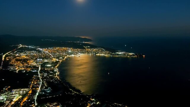 Gelendzhik, Russia. Night view of Gelendzhikskaya Bay. Fatty Mys. Night panorama of the city. Black Sea. Drone footage