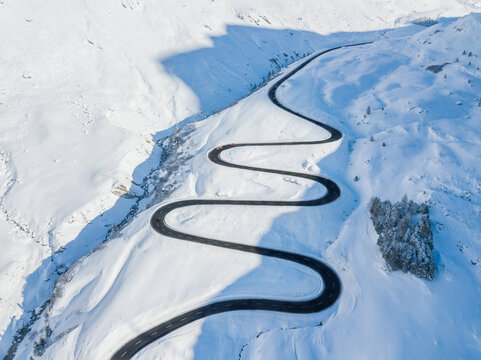 Drone view of the winding road over the Julier Pass in Swiss Alps mountain in winter, Canton Grison, Switzerland. Julier Pass is the only pass that is open through the year in Switzerland.