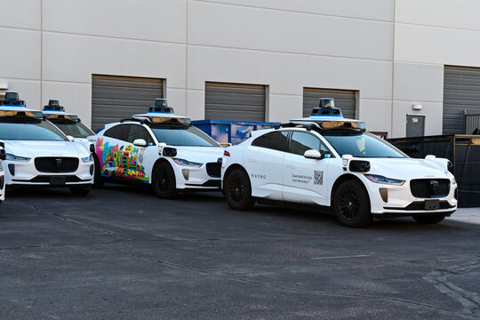 Waymo Jaguar I-PACE autonomous robotaxis parked at the Waymo Driver Integration Plant, showing sensor-equipped vehicles used for driverless ride-hailing and autonomous transportation
