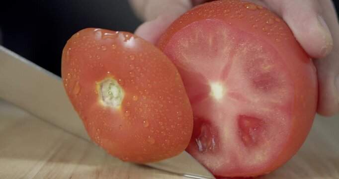 Macro wide close up of knife slicing and chopping a red tomato salad, food,