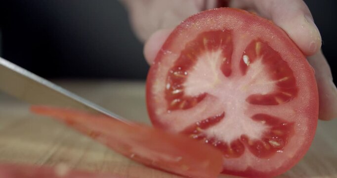 Macro wide close up of knife slicing and chopping a red tomato salad, food,