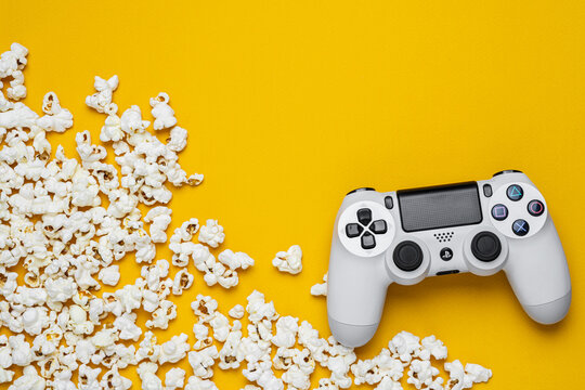 September 1, 2026, Odessa, Ukraine. White Sony PS4 DualShock controller with popcorn on bright yellow back