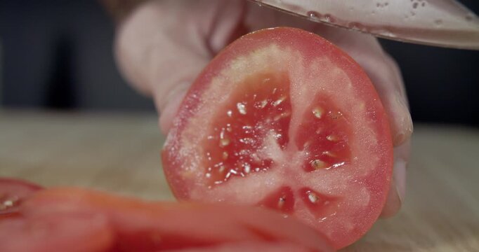 Macro wide close up of knife slicing and chopping a red tomato salad, food,