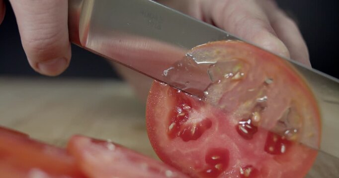 Macro wide close up of knife slicing and chopping a red tomato salad, food,