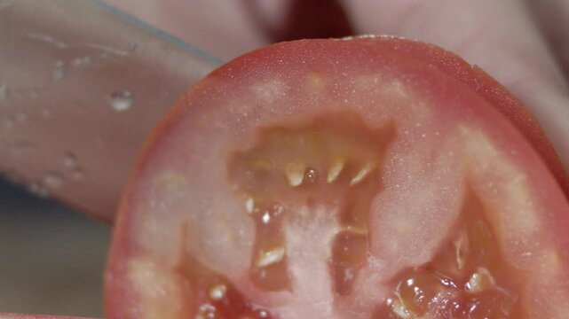 Macro wide close up of knife slicing and chopping a red tomato salad, food,