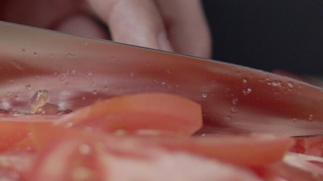 Macro wide close up of knife slicing and chopping a red tomato salad, food,