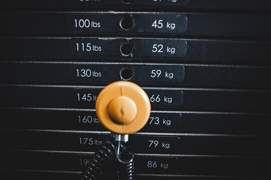 Weight Stack Moving As Part Of A Strength Training Machine In A Close-Up View