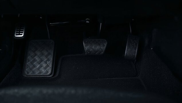 Car pedals in a vehicle cabin, accelerating, braking, and clutching while driving, manual transmission concept