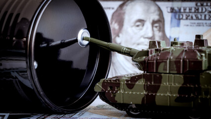 Naklejka premium Black barrel looms large beside a toy tank