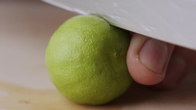 Macro lemon being sliced and dropped slow motion knife lime cutting