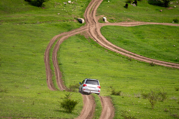 The car is driving on an off-road mountain road. © Daniel
