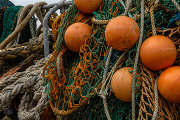 Close up view of tangled fishing nets and orange buoys on a boat dock  © Mark Walker