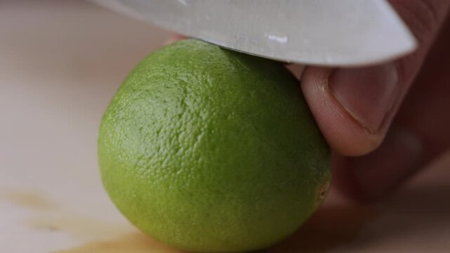 Macro lemon being sliced and dropped slow motion knife lime cutting