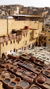 Vats of chemicals and dyes, with hides hanging above to dry, in the courtyard of the Chouara Tannery in Fez, Morocco