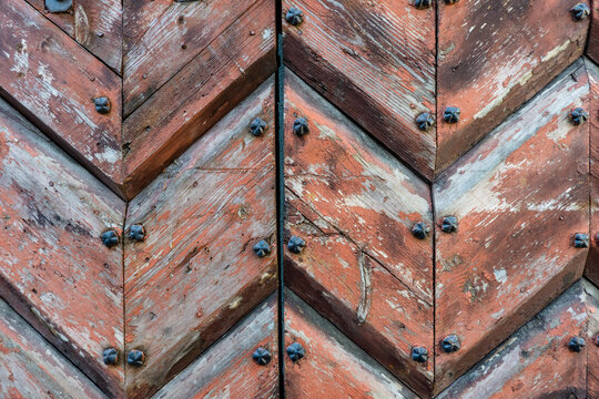 Close-up of an old weathered wooden door with metal studs outdoors