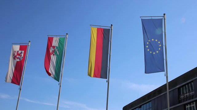 Waving flags from European Union, Germany, Northrhine Westphalia and Dusseldorf on blue sky background show european and germany represented by Germany flag and European Union set of flags as set