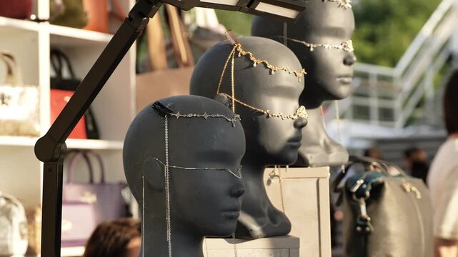 Mannequin heads displaying fashion jewelry and hair accessories at a market stall