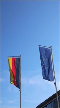 Waving flags from European Union and Germany a on blue sky background show european and germany represented by Germany flag and European Union flag as partners both flags as set