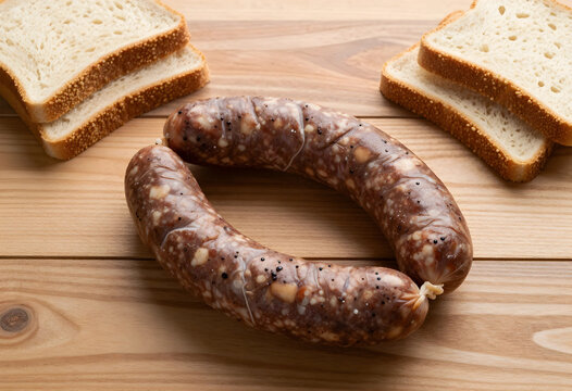Gastronomy and traditional food, raw blood sausage with slices of white bread on a rustic wooden table for culinary preparation and home cooking