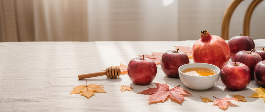 Rosh Hashanah table setting with apples honey and pomegranate. Jewish New Year symbols with autumn leaves