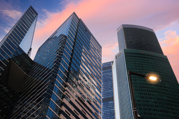 Fototapeta premium Sunse t sky displays pink and orange hues, Tall skyscrapers dominate the skyline