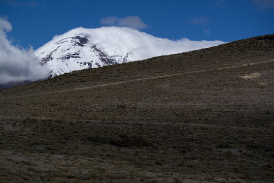 Majestic snowy summit of Chimborazo mountain under clouds in the Ecuadorian Andes. 