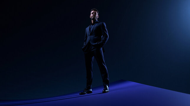 Confident Businessman in Suit Standing in Dramatic Studio Lighting