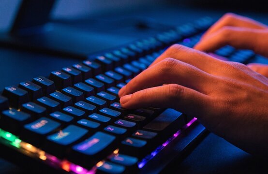 Detailed view of hands engaged in typing on a vibrant mechanical keyboard featuring illuminated keys designed for passionate pc gaming fans